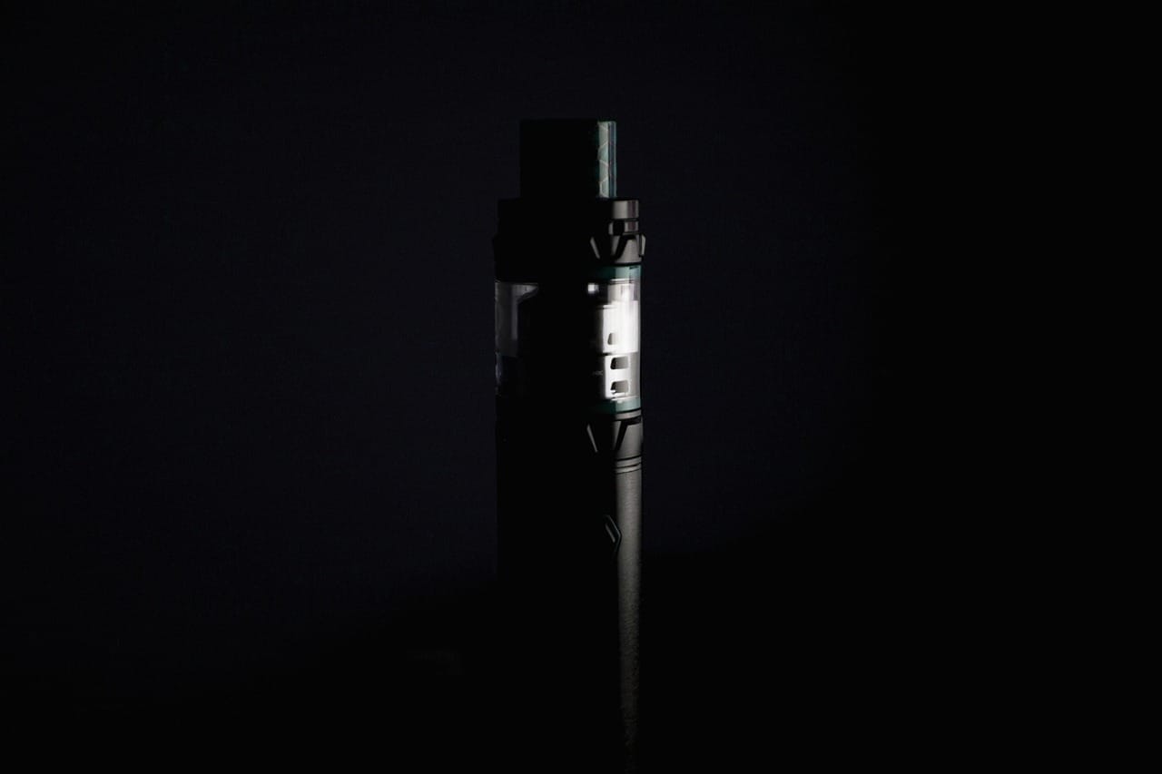 Black vape device with tank showcased against a dark background – premium vaping equipment